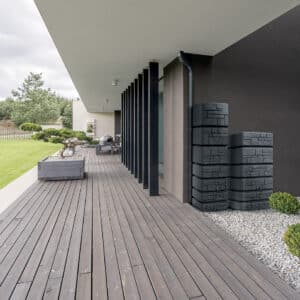 Side view of wooden board floor and black pillars of terrace with Bonsai tree