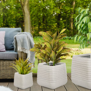 Beautiful green garden with wicker terrace furniture and trees