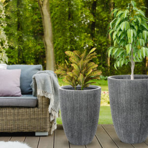 Beautiful green garden with wicker terrace furniture and trees